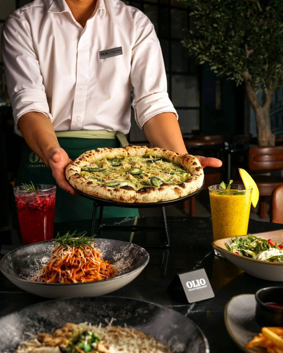 OLIO team presenting a freshly prepared pizza